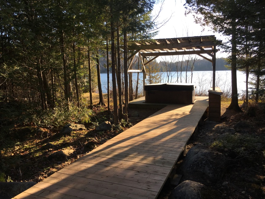 Sentier de bois menant au spa extérieur, face au lac